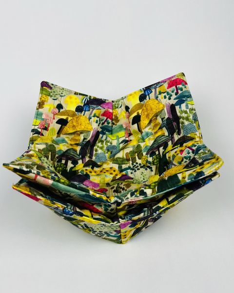 Two nested bowl cozies in a colorful mushroom print